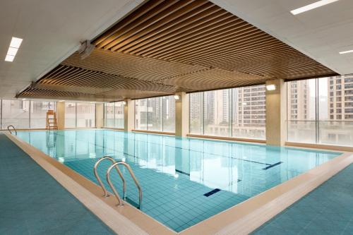 成都成都象南里凯悦嘉寓酒店的一座大型游泳池,位于一座带窗户的建筑内