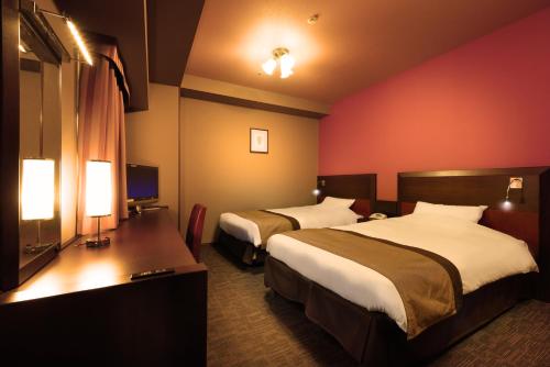 仙台仙台蒙特埃马纳酒店的酒店客房设有两张床和电视。