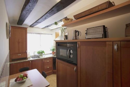 潘普洛纳Altalea的厨房配有木制橱柜和1张带水果碗的桌子