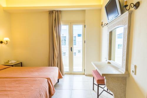 斯塔里斯Pela Sofia的配有一张床、一张书桌和一扇窗户的酒店客房