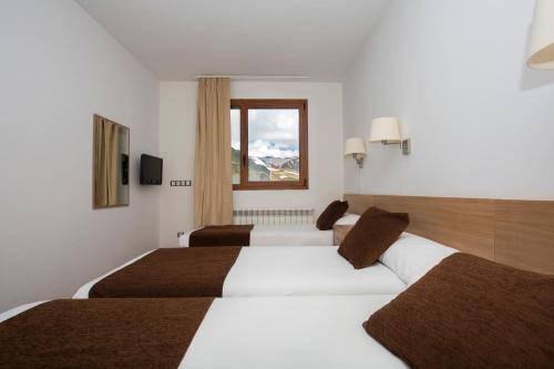 帕斯底拉卡萨Hotel Catalunya Ski的酒店客房设有两张床和窗户。