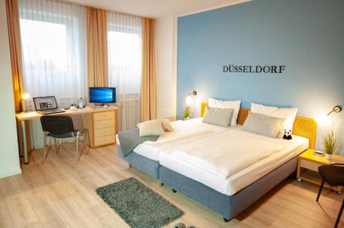 杜塞尔多夫KEMPE康福特酒店的一间卧室配有一张大床和一张带电脑的书桌