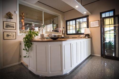 利多迪耶索罗Hotel Jesolo Sand的厨房配有白色橱柜和大镜子