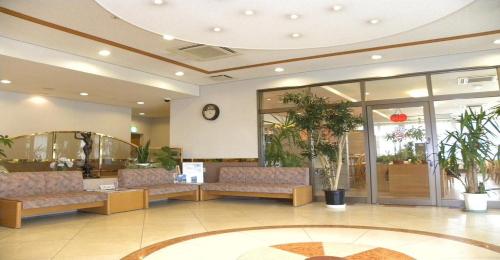 米泽市Hotel Benex Yonezawa / Vacation STAY 14346的大堂设有带沙发和时钟的等候室