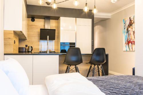 卡托维兹Fabulous apartment in heart of Katowice的厨房前设有一间卧室,配有一张床和两把椅子