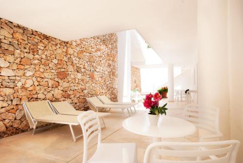佩斯科勒海滨Hotel Beach Salento的配有桌椅和石墙的房间