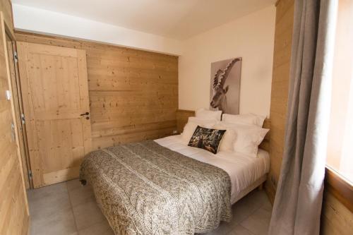 瓦卢瓦尔Le Bianca 102 Residence l'Epinette的一间卧室配有一张木墙床
