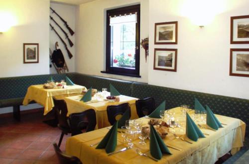瓦尔迪登特罗Chalet Villa Valania的用餐室设有两张带黄桌布的桌子