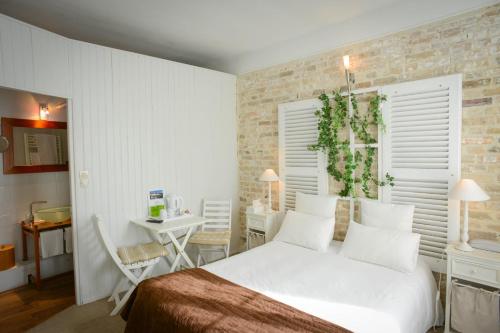 卡朗唐奥贝奇诺曼德酒店的卧室配有白色的床和桌椅
