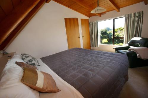 奥波蒂基Capeview Cottage的一间卧室设有一张大床和一个窗户。