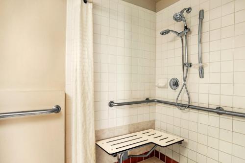 佛罗里达市Belmont Inn & Suites的带淋浴的浴室和长凳