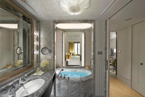 台北Mandarin Oriental, Taipei的一间带浴缸和大镜子的浴室