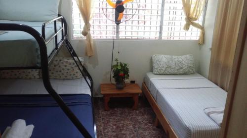 拉斯加勒拉斯Las Galeras Island Hostel的小房间设有两张双层床和一张桌子