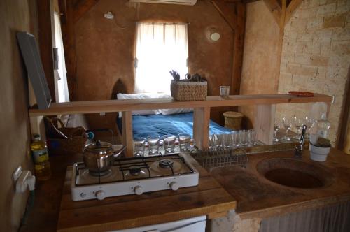 祖奇姆Desert Days mud cabin's Resort的客房内设有带炉灶和水槽的厨房