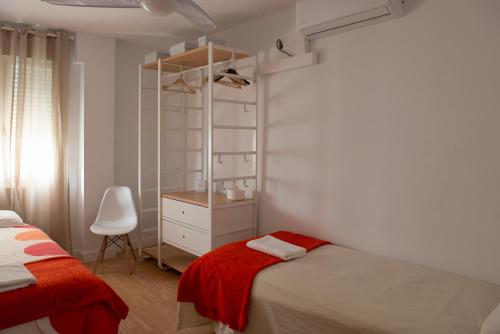 加的斯Casita Coqueta Free Parking的一间卧室配有一张床、梳妆台和椅子