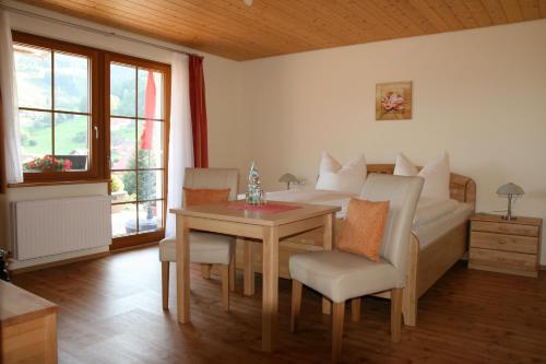 韦登迪Gästehaus Sonnhalde的卧室配有一张床和一张桌子及椅子
