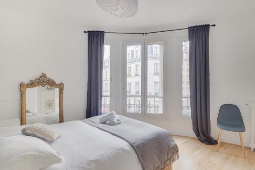 巴黎Lovely Parisian Flat - Louvre rue St Honoré的一间卧室配有一张大床和镜子