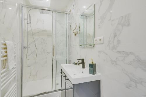 巴黎Lovely Parisian Flat - Louvre rue St Honoré的带淋浴和盥洗盆的白色浴室