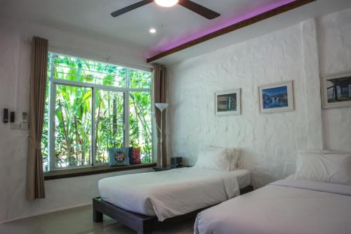 象岛至尊象岛度假村的带窗户的客房内的两张床