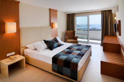 库萨达斯City's Hill Hotel的酒店客房设有一张床和一个阳台。