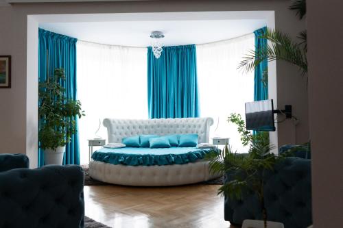 尼什罗特斯戈尔尼酒店的客厅配有白色沙发和蓝色窗帘
