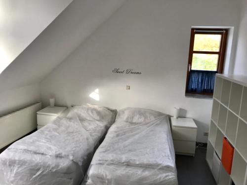 阿尔滕霍尔茨霍提瑙公寓的一张带白色床单的睡床