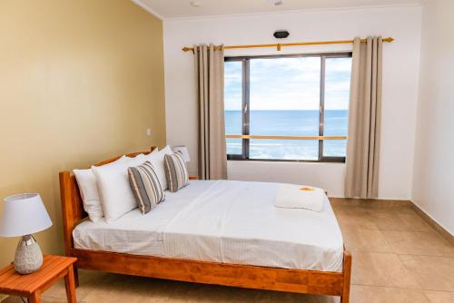 马埃岛Villa Lima的一间卧室设有一张床和一个大窗户