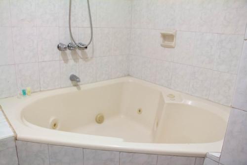 利马Hotel Internacional的白色瓷砖浴室内的白色浴缸