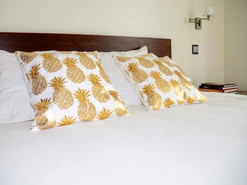 大里贝拉Cabo da Vila Guesthouse的床上配有两张 ⁇ 萝枕头