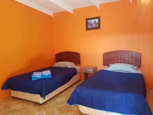 圣佩德罗·德·阿塔卡马Hostal Casa Colque的橙色墙壁客房的两张床