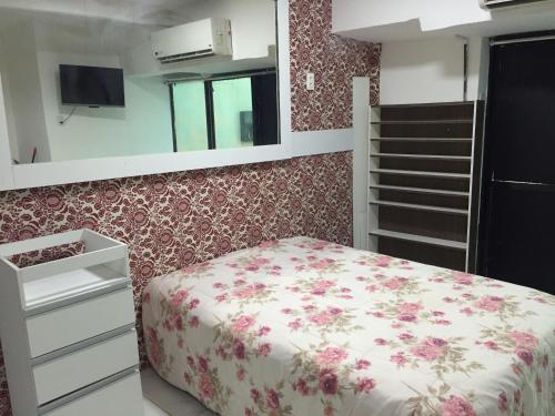 萨尔瓦多Loft Morada do Porto的一间卧室配有一张带花卉图案墙壁的床