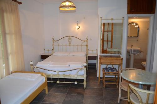 佩科霍里Hotel Rigakis的一间卧室配有两张床、一张桌子和一面镜子