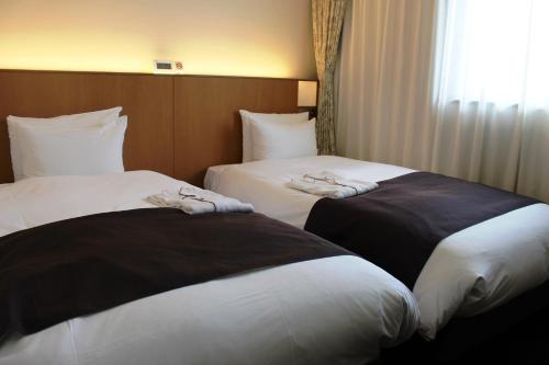 仙北角馆民宿酒店的两张位于酒店客房的床,配有毛巾