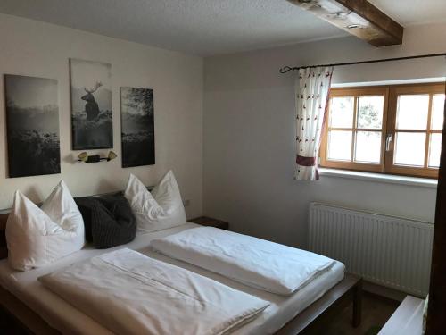 菲根贝格Apart Lisi的一间卧室配有一张带白色床单的床和一扇窗户。