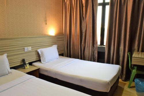 瓜拉丁加奴DJ CITI INN HOTEL的酒店客房设有两张床和窗户。