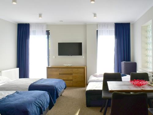 姆拉哥沃Apartamenty CityCenter的一间卧室配有两张床、一张桌子和一台电视。