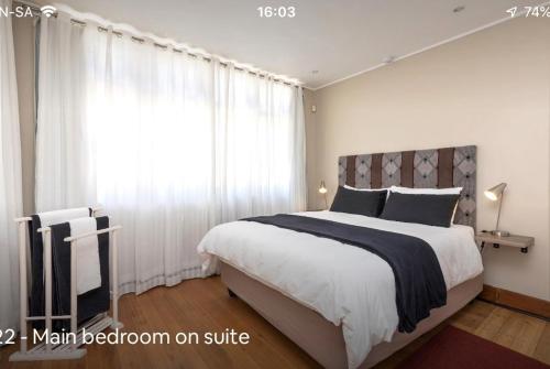 约翰内斯堡Forest Haven的一间卧室设有一张大床和大窗户