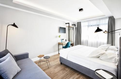 雅典雅典艺术家酒店的一间卧室配有一张床和一张沙发
