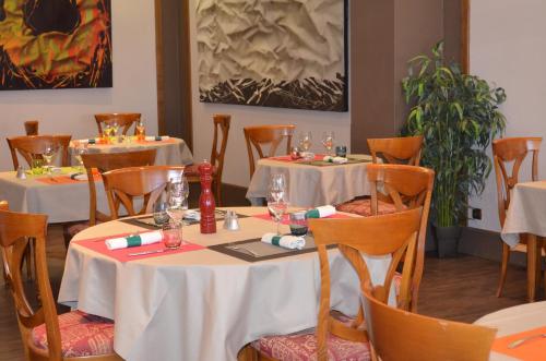 日安拉普尔拉德酒店的一间用餐室,配有2张带白色桌布的桌子