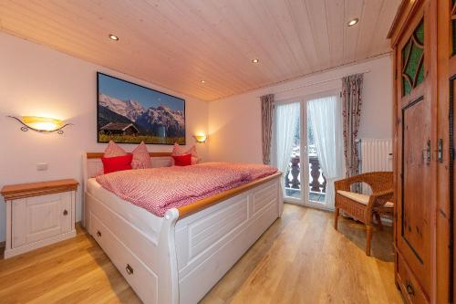 米滕瓦尔德Ferienwohnung Sonnenhäusl的卧室配有带红色枕头的大型白色床