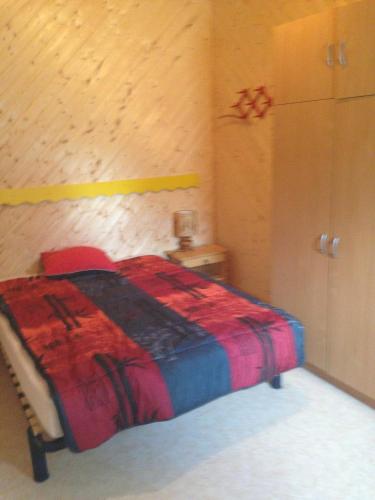 艾克塞恩维克斯Les Marmottes的一间卧室配有一张带红色毯子的床