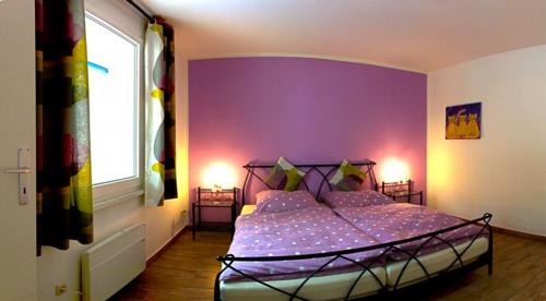 马林费尔德Uns' Husing的一间卧室配有一张紫色墙壁的床