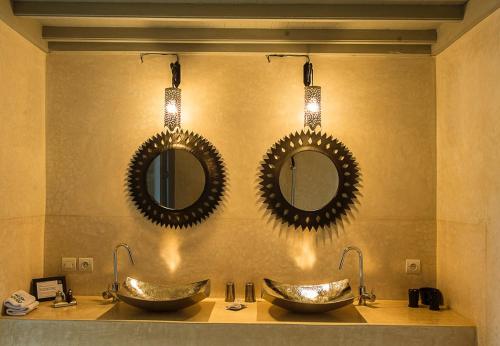 梅克内斯里亚德亚姆查旅馆的浴室设有两个水槽和两面墙上的镜子