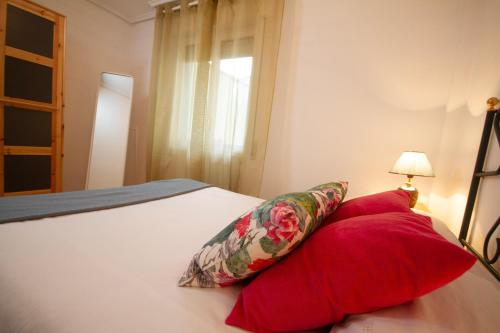 安普埃罗Los Respigos Ampuero的一间卧室配有一张带两个红色枕头的床