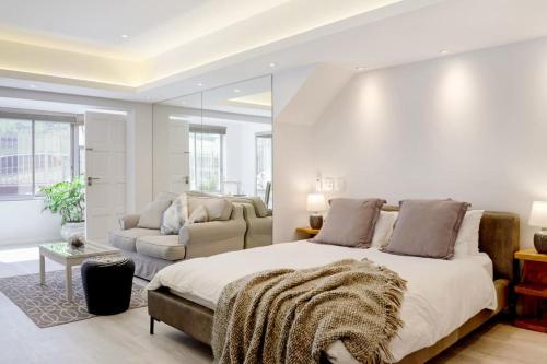 开普敦Camps Bay Nest的白色卧室设有一张大床和一张沙发