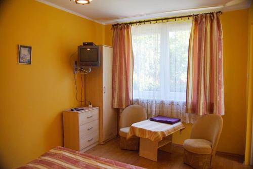 科乌切沃Wilcza Chata的一间卧室配有一张床、一张桌子和一个窗户。