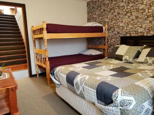 蓬塔阿雷纳斯Hostal Torres del Paine 2的一间卧室设有一张双层床和一堵石墙