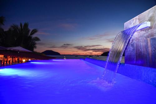 锡瓦塔塔内霍Arena Suites的游泳池,在晚上设有喷泉