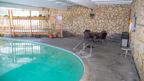 圣西米恩银色冲浪汽车旅馆的一座带桌椅的游泳池