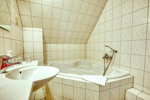 伯尔格伦德-雷特维施Hotel Kiebitz an der Ostsee的浴室配有盥洗盆和浴缸。